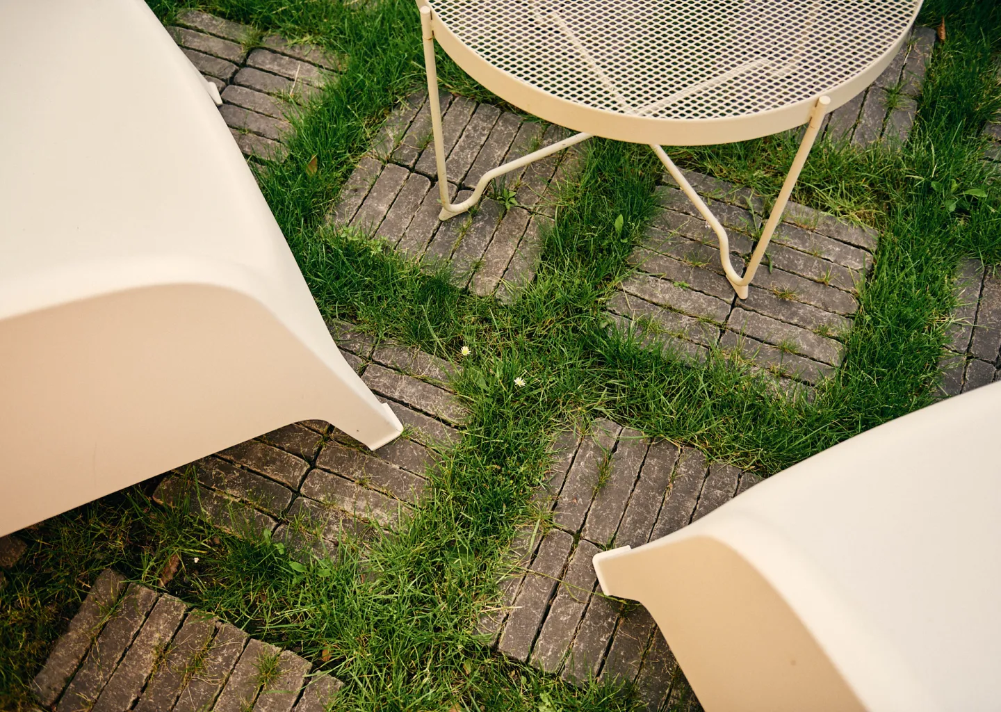 Semi-verhard terras met gras tussen kleiklinkers ontworpen door Tuinen Cobbaert